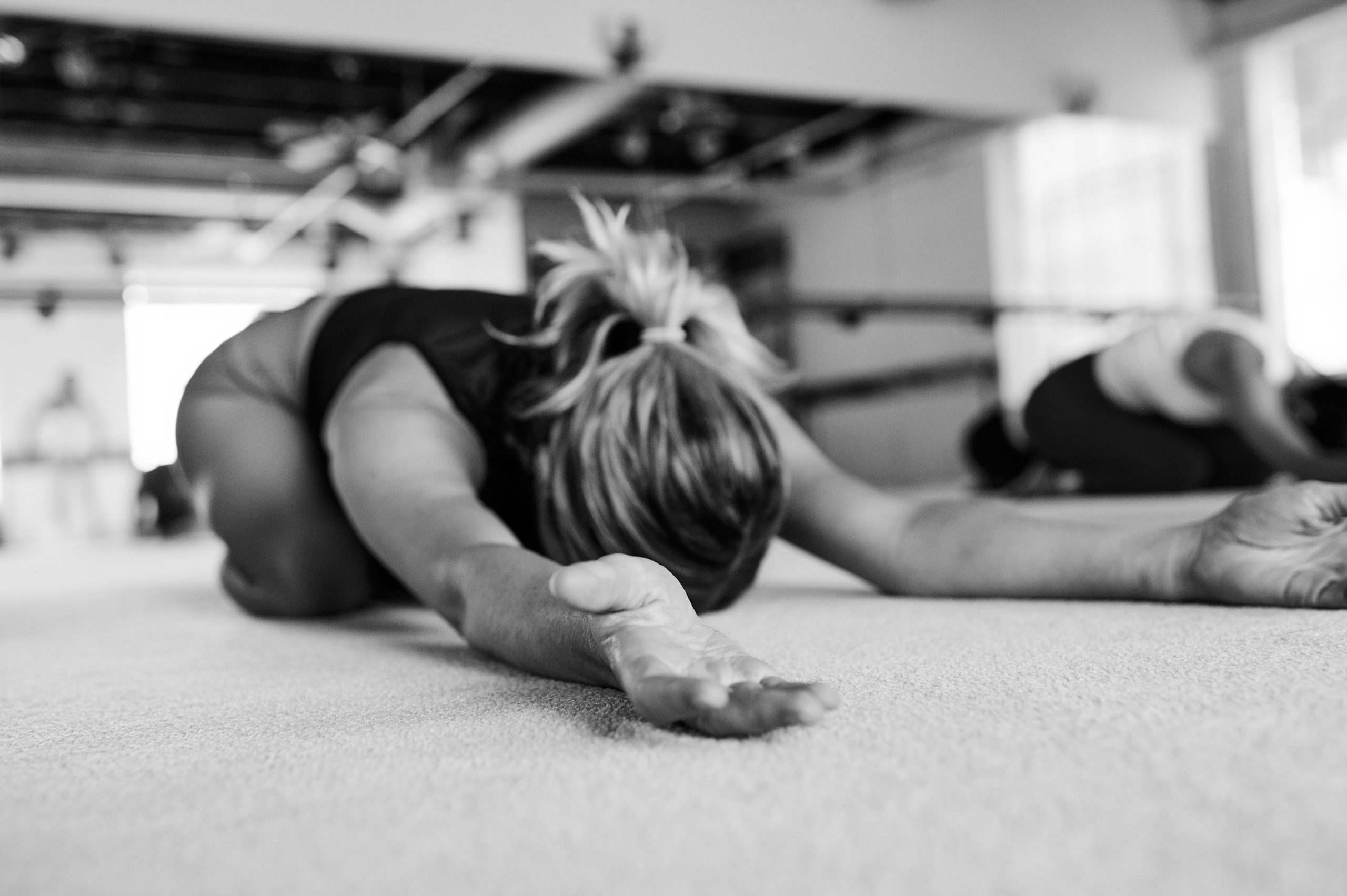Woman on the floor at Bar Method studio doing childs pose