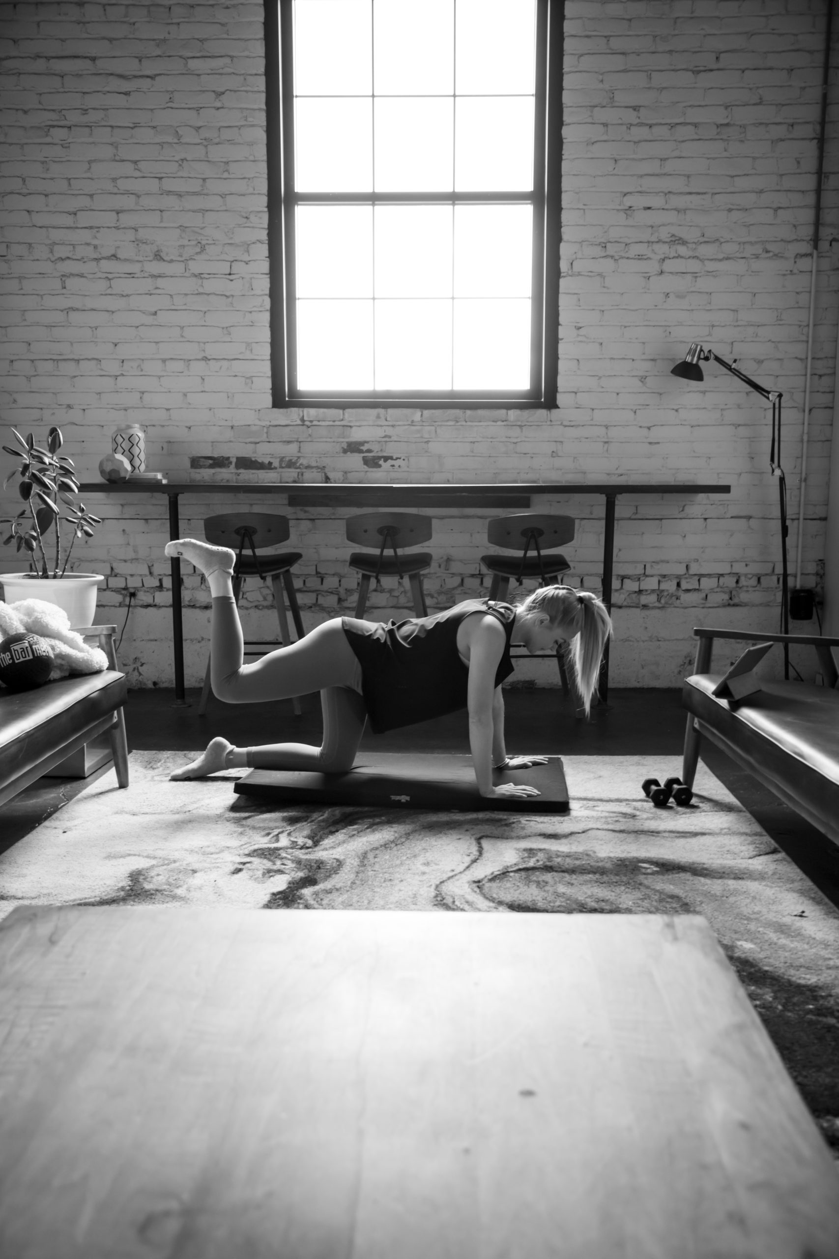 Black and white image of woman practicing Bar at home.